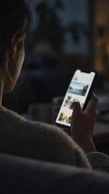 A phone held in one hand showing an app screen